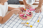 The PlanToys wooden birthday cake includes 6 slices of double sided cake