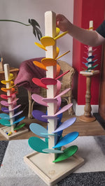 Large Magic Wood Marble Tree, a wooden Ball Run with rainbow coloured leaves, being played with by a child.