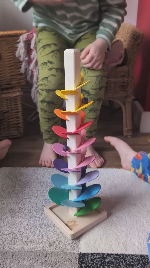 Magic Wood Marble Tree Mini, a wooden Ball Run with rainbow coloured leaves, being played with by children.