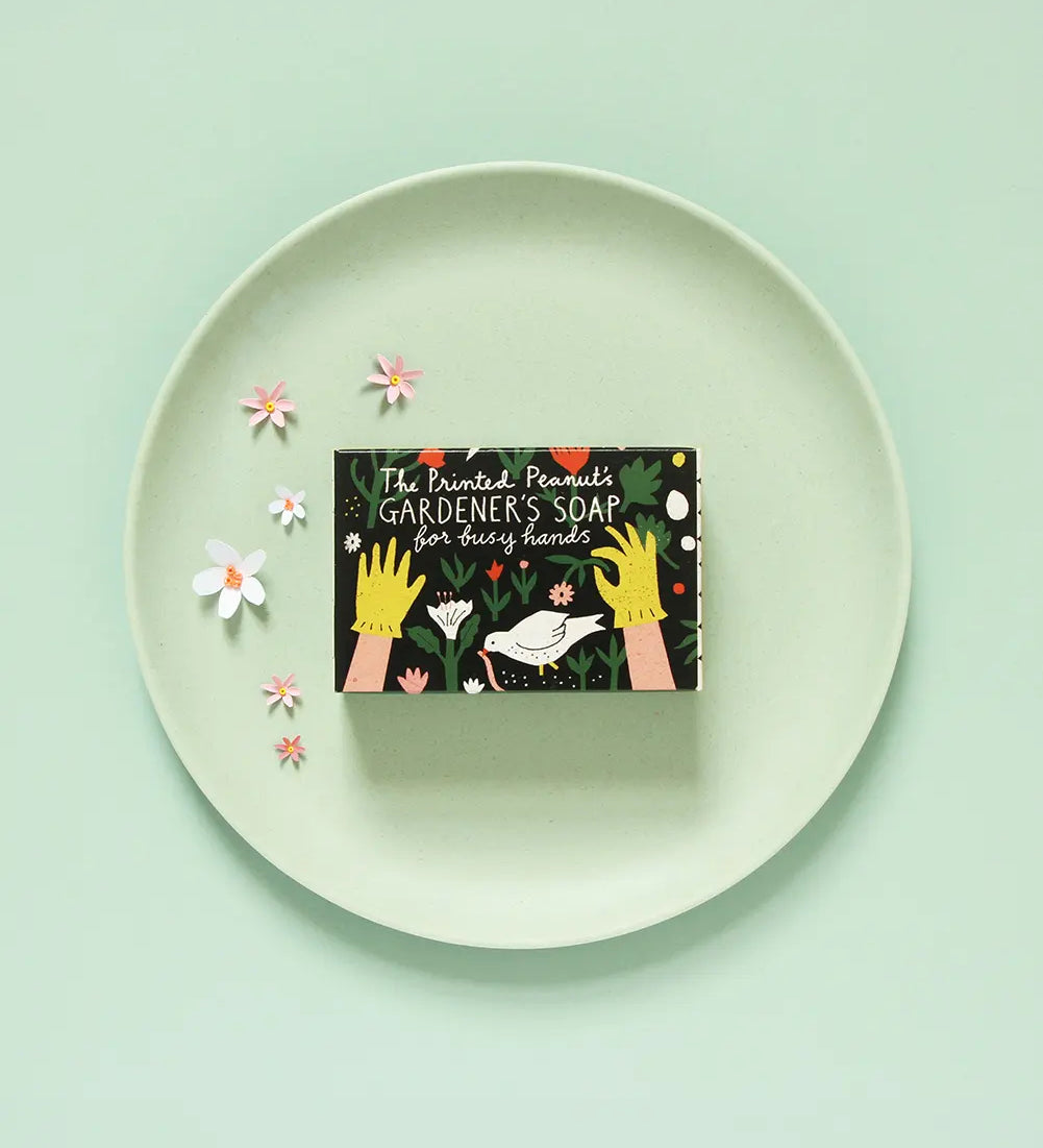 The Printed Peanut Gardener’s peppermint soap gift box on green plate with flowers, natural exfoliating poppyseed soap for gardeners.