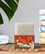 Printed Peanut cedarwood natural soap bar placed on a squirrel themed illustrated cardboard packaging box.