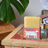 Printed peanut ylang ylang natural soap bar placed on top of the red decorative cardboard packaging box with dalmatian style dog illustration.