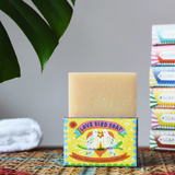 Printed Peanut tea tree, lemongrass, lavender and peppermint soap bar in a love bird themed illustrated box. The natural soap bar has been placed on top of the cardboard packaging box.
