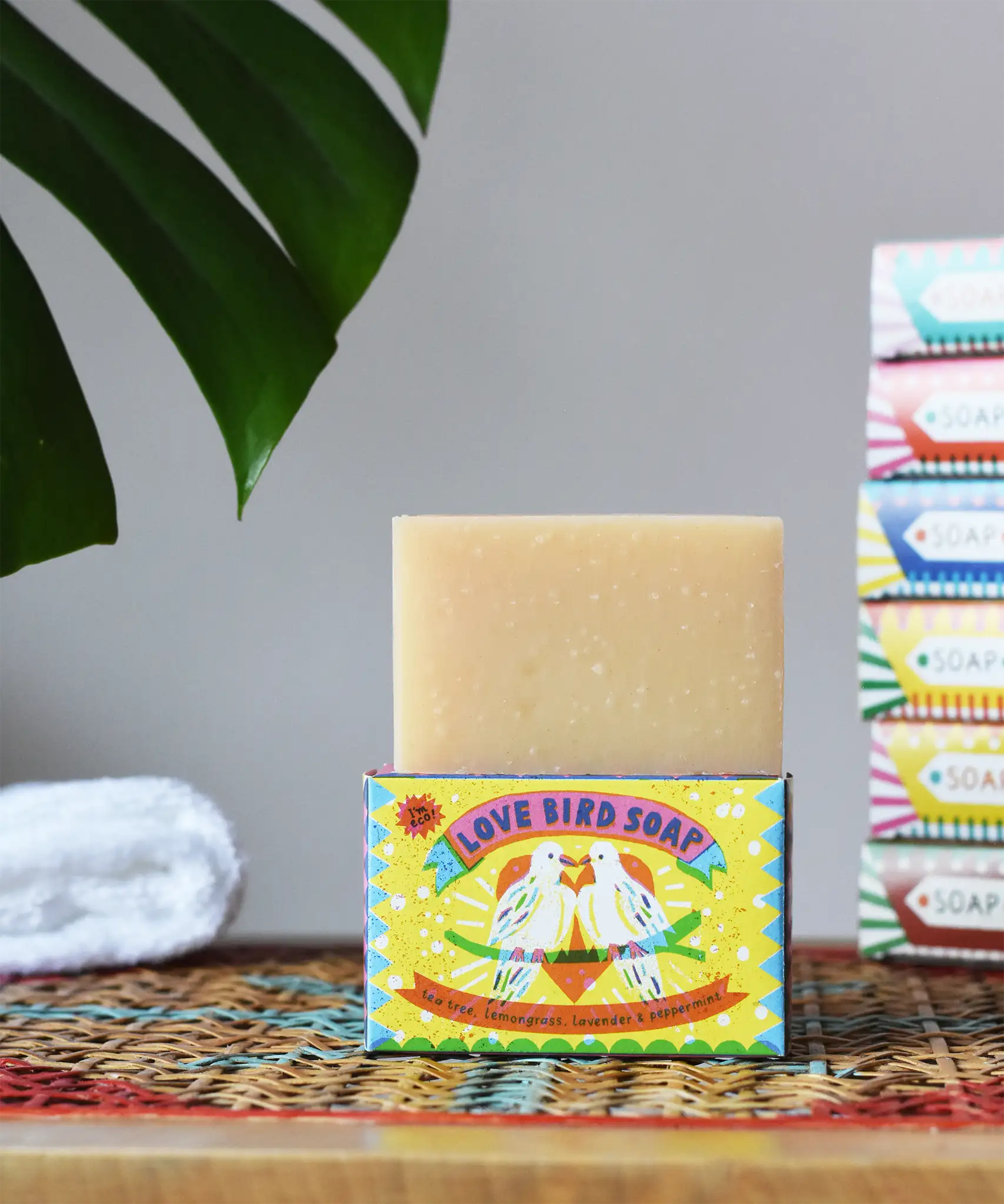 Printed Peanut tea tree, lemongrass, lavender and peppermint soap bar in a love bird themed illustrated box. The natural soap bar has been placed on top of the cardboard packaging box.
