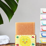 Printed Peanut orange and grapefruit natural soap bar placed on a you are my sunshine themed illustrated packaging box. 
