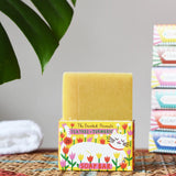 Printed Peanut tea tree and turmeric natural soap bar placed on its decorative cat illustrated cardboard packaging box. 