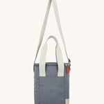 The extendable sholder strap on the Lola & Lykke Milk Cooler Bag is shown in an upwards position, along with the carry handles