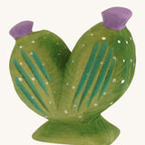 Side view of the cushion cactus with purple flowers on a cream background