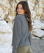 A side view of the Rapanui striped  t-shirt in solent oat and navy stripes design worn by a woman. Showing the oat and navy stripe design on organic cotton fabric