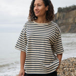 A women wearing the Rapanui oversized striped t-shirt. A organic cotton top in neutral and navy stripe with a neutral neck trim