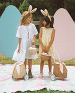 The back view of the Olli Ella Rattan Bunny Luggy with Lining – Gumdrop. A beautifully woven Luggy roll along basket with a light peach lining and gum drop detail