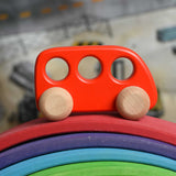 A red coloured Bajo bus wooden push along toy placed on a Gluckskafer bridge. These heirloom quality toys by Bajo are part of a wide range of wooden toys available here at Babipur. 