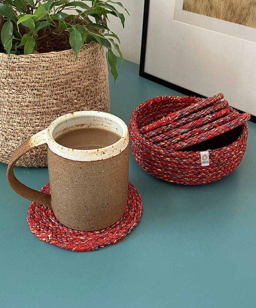 Respiin recycled cotton multicoloured coasters in its matching holder on top of a surface with a mug on top of a coaster