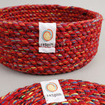 A close up view of the Respiin multicoloured recycled cotton coaster holder showing the weave detail and brand patch stitched on the rim