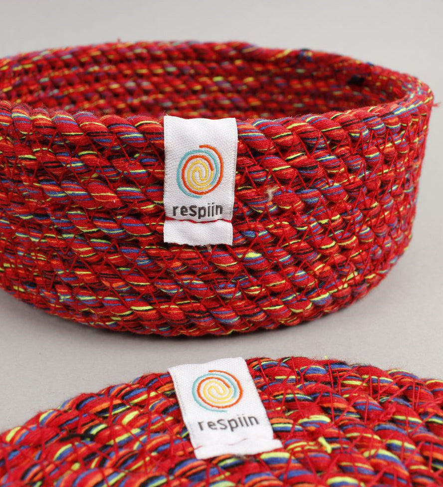 A close up view of the Respiin multicoloured recycled cotton coaster holder showing the weave detail and brand patch stitched on the rim