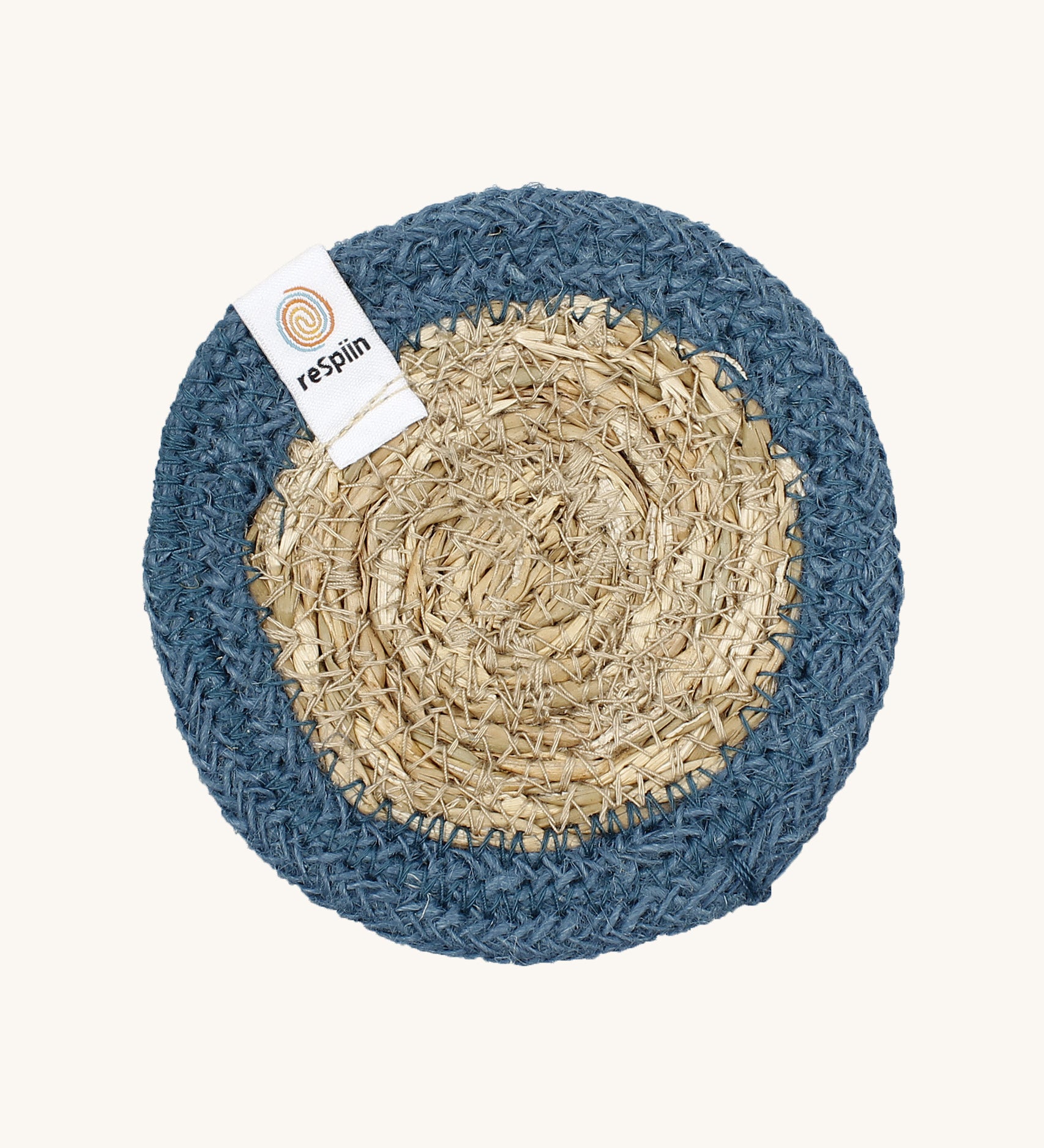 The ReSpiin natural jute and seagrass coaster in denim blue.