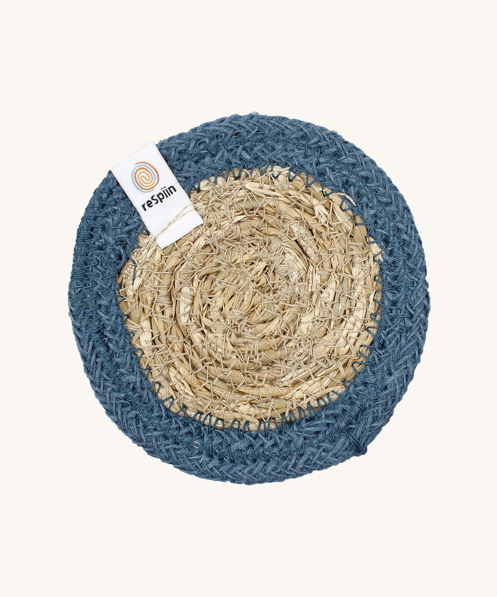 The ReSpiin natural jute and seagrass coaster in denim blue.