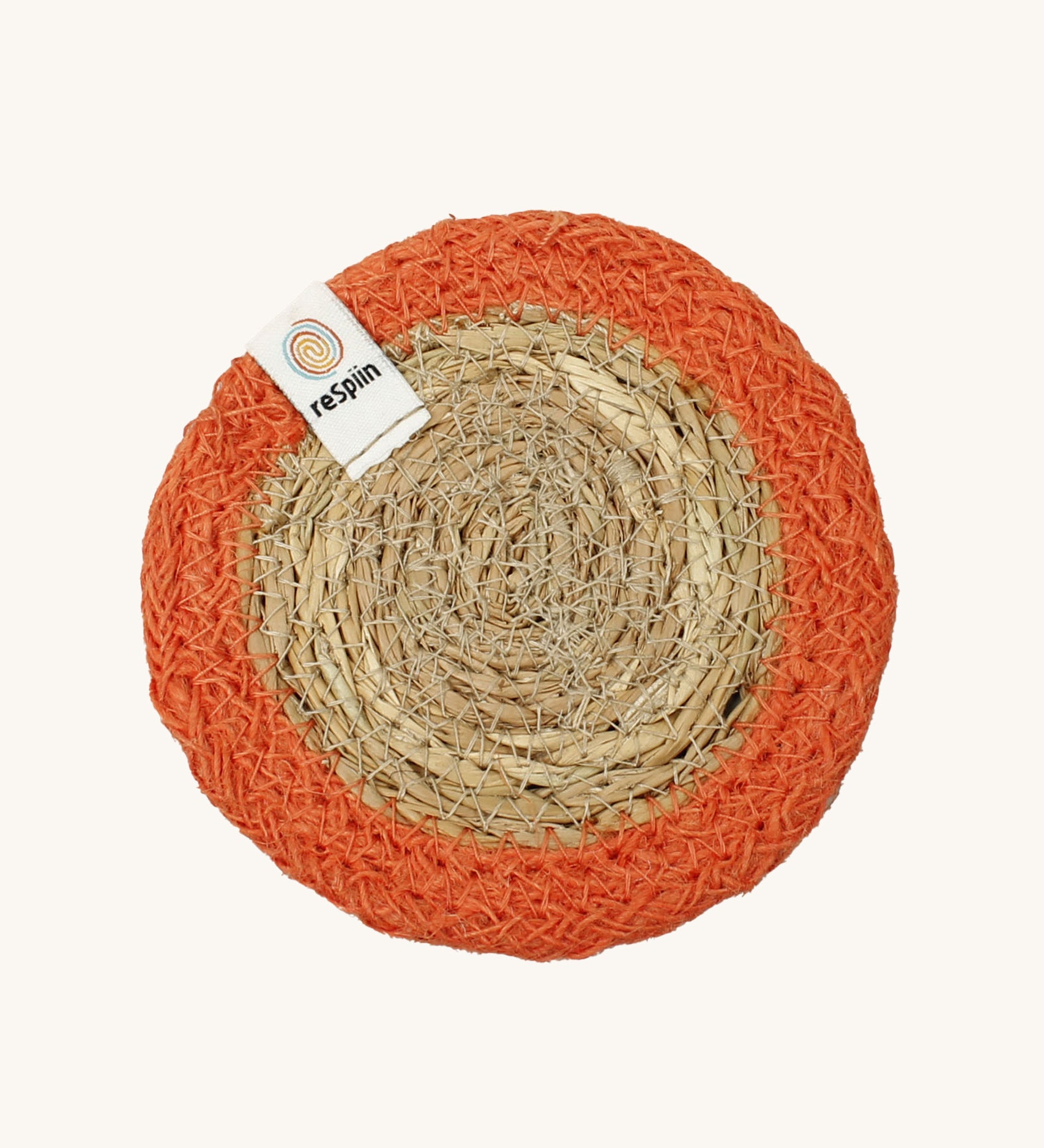 The ReSpiin natural jute and seagrass coaster in orange.