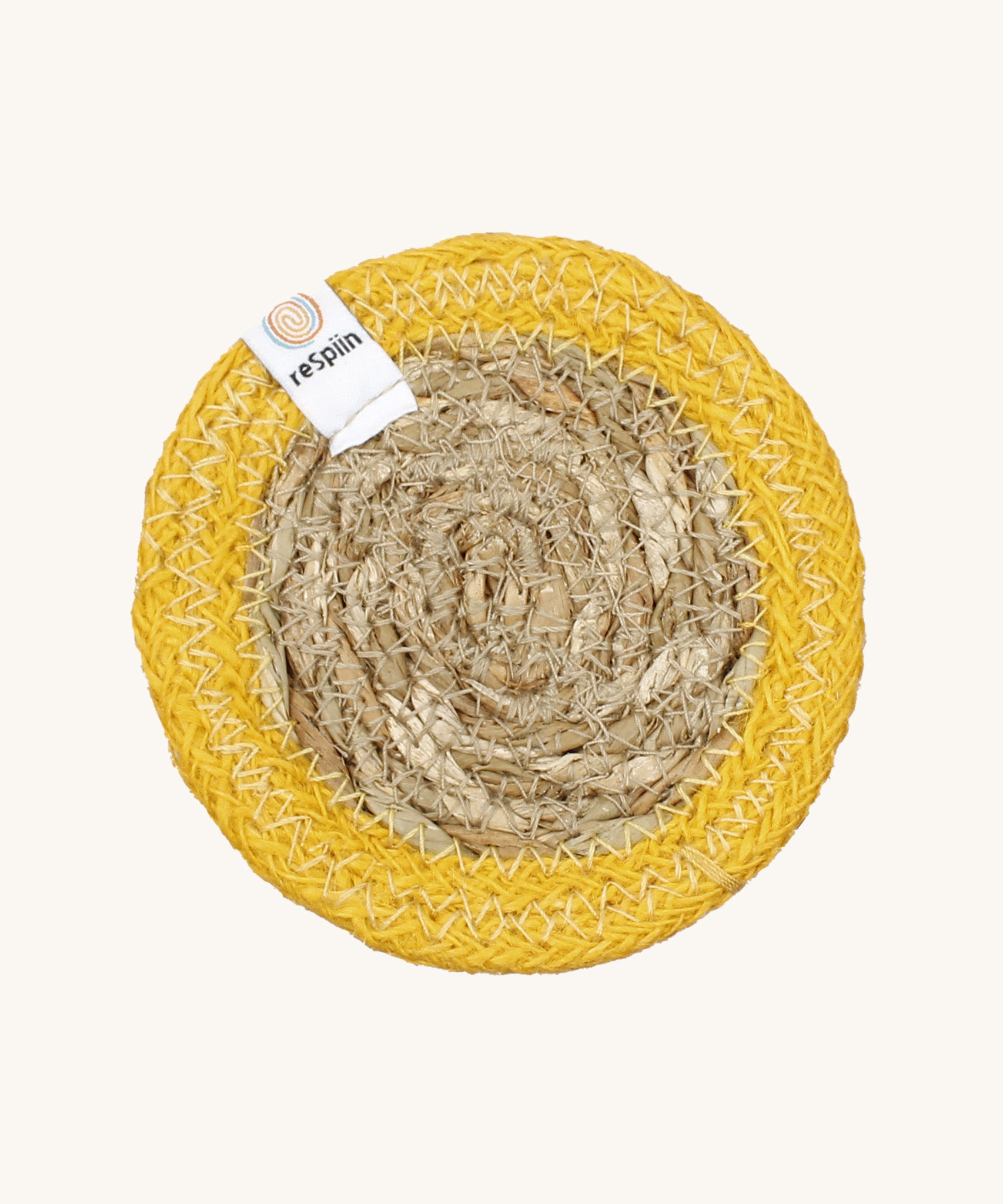 The ReSpiin natural jute and seagrass coaster in yellow.
