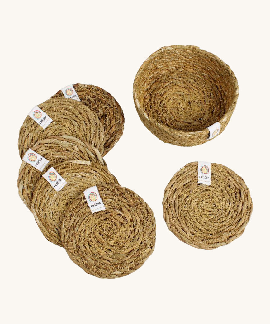 A set of 6 Respiin seagrass coasters in natural with a matching holder. Features a brand patch stitched on the rim.
