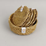 A close up view of the Respiin seagrass coasters inside the matching holder 