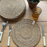 A top down view of the Respiin seagrass tablemat on a wooden table 