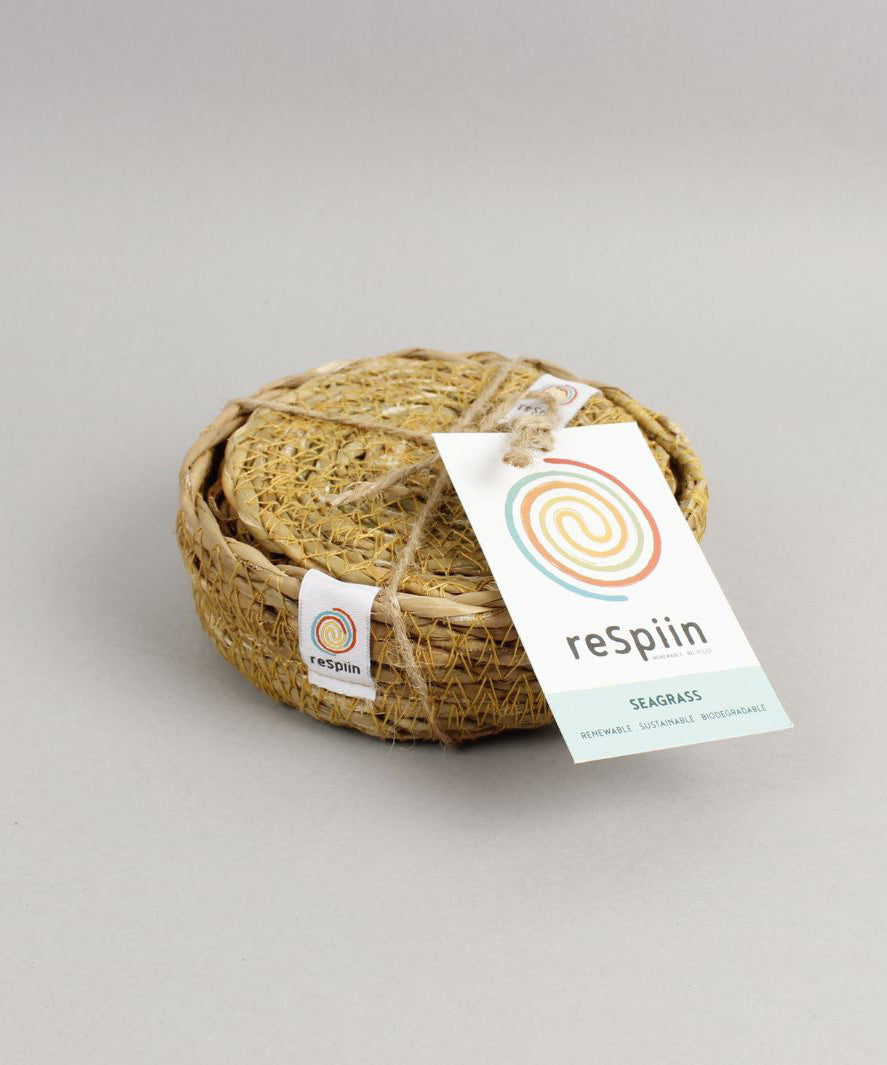 A close up view of the Respiin seagrass coasters inside the matching holder tied up with string. 