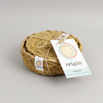 A close up view of the Respiin seagrass coasters inside the matching holder tied up with string. 