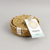 A close up view of the Respiin seagrass coasters inside the matching holder tied up with string. 
