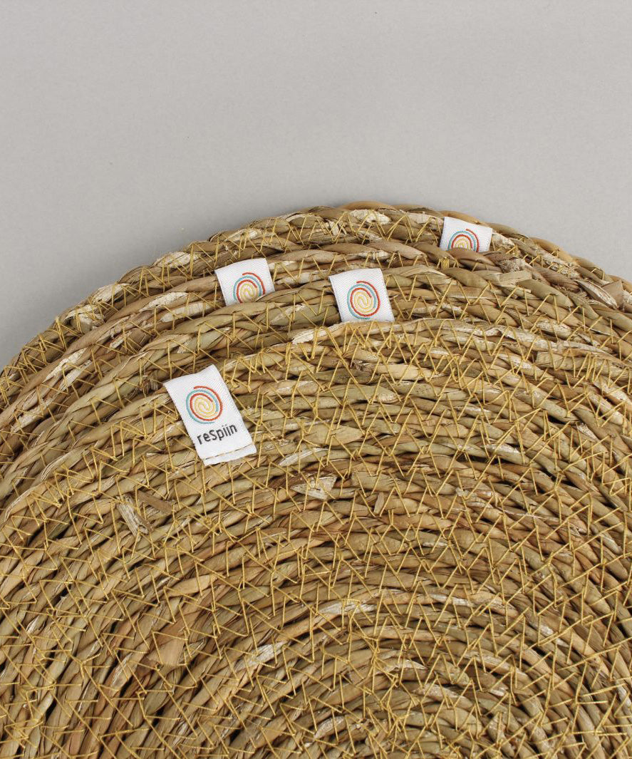 A close up view of the Respiin seagrass coasters showing the woven detail and brand patch stitched on the rim