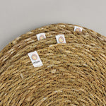 A close up view of the Respiin seagrass coasters showing the woven detail and brand patch stitched on the rim