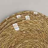 A close up view of the Respiin seagrass coasters showing the woven detail and brand patch stitched on the rim