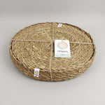 A close up view of the Respiin seagrass tablemat inside the matching holder tied up with string. 