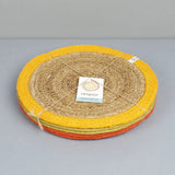 Stack of Respiin set of 6 jute table mats with a yellow, green and orange trim held with yarn