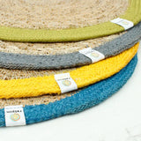 A stack of 4 Respiin jute table mats from different sets showing coloured edging and brand tab 