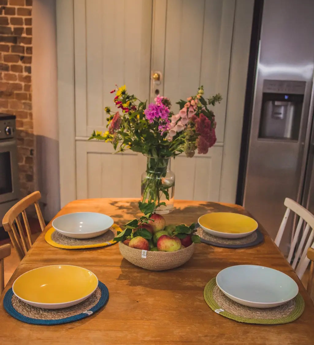 4 Respiin jute table mats from different 6 packs including natural, brights and rainbow sets on a dining table