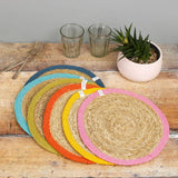Set of 6 Respiin jute table mats with a bright rainbow inspired edging on a wooden table