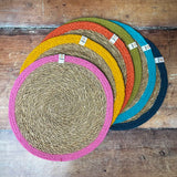 Respiin set of 6 jute table mats with rainbow inspired colours on the rim laid flat on a wooden table