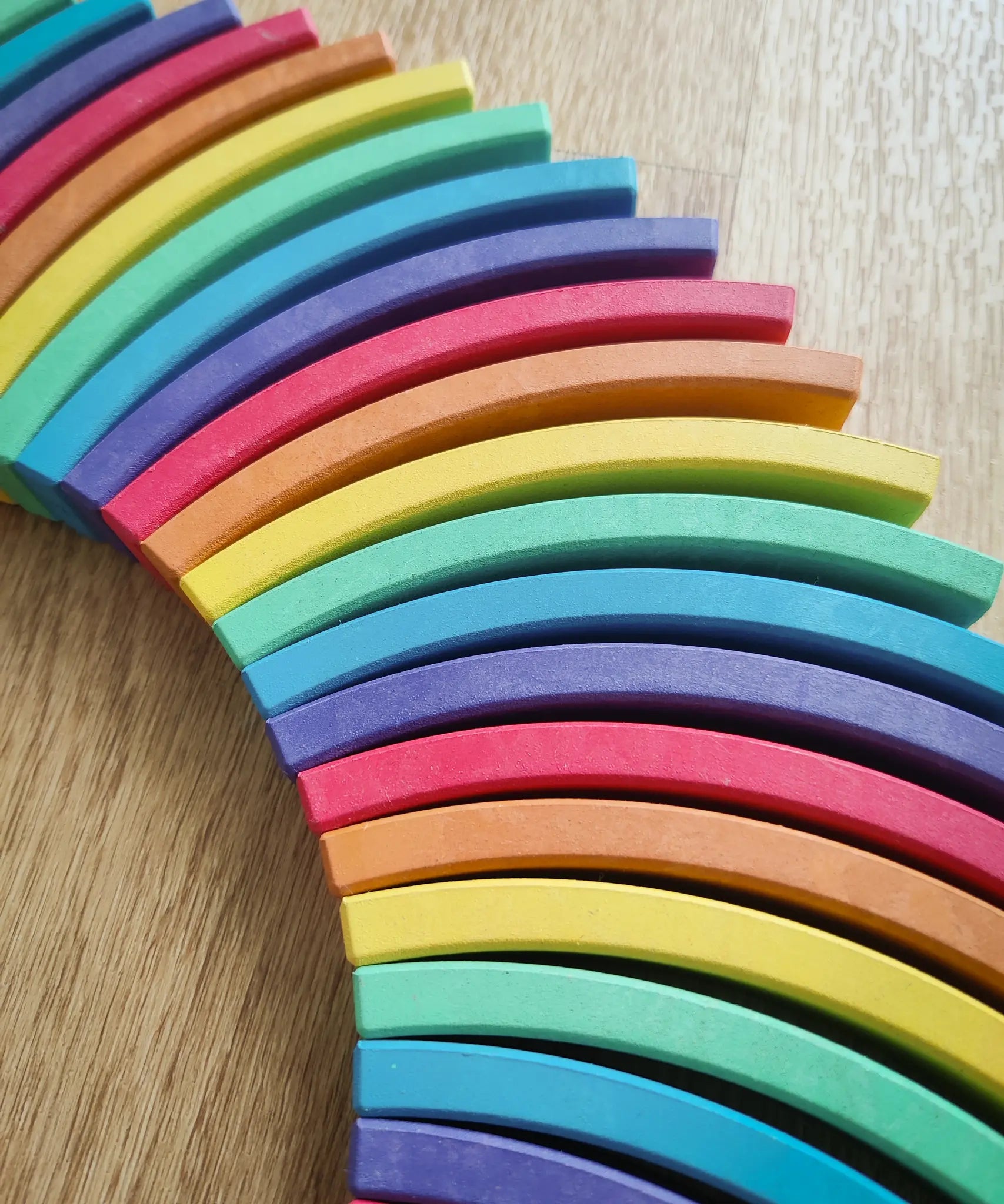 Close-up of a curved rainbow-colored wooden blocks from the Abel blocks mini rewood Rainbow wooden stacking blocks  sets.