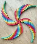 Abel blocks mini rewood Rainbow wooden stacking blocks placed in a pattern on a wooden surface.