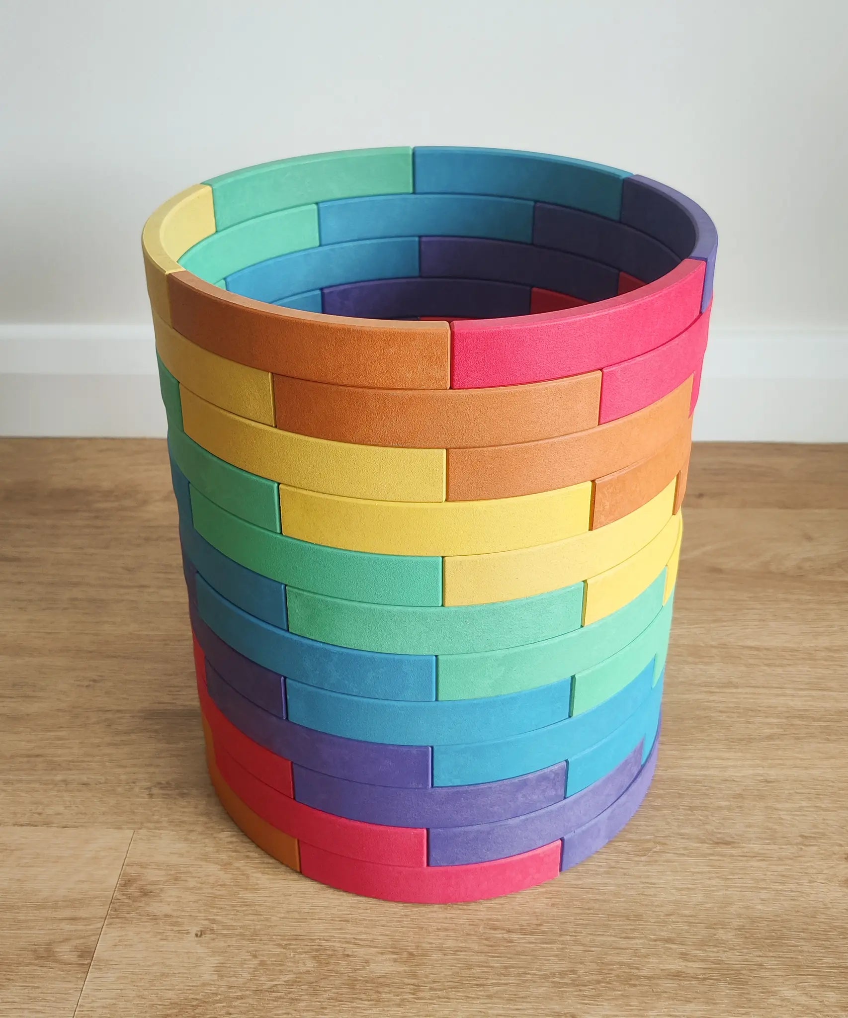 Abel blocks mini rewood Rainbow wooden stacking blocks stacked up to create a cylinder.