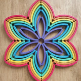 Abel blocks mini rewood Rainbow wooden stacking blocks placed in a flower pattern.