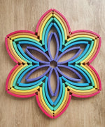 Abel blocks mini rewood Rainbow wooden stacking blocks placed in a flower pattern.
