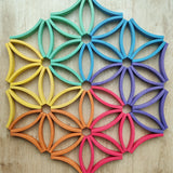 Abel blocks mini rewood Rainbow wooden stacking blocks placed on the floor to create a floral mandala.