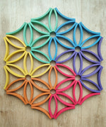 Abel blocks mini rewood Rainbow wooden stacking blocks placed on the floor to create a floral mandala.