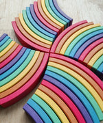 Abel blocks mini rewood Rainbow wooden stacking blocks arranged in pattern on a light wood floor.