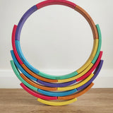 Abel blocks mini rewood Rainbow wooden stacking blocks stacked to create a circle balanced on more blocks.