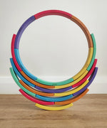 Abel blocks mini rewood Rainbow wooden stacking blocks stacked to create a circle balanced on more blocks.