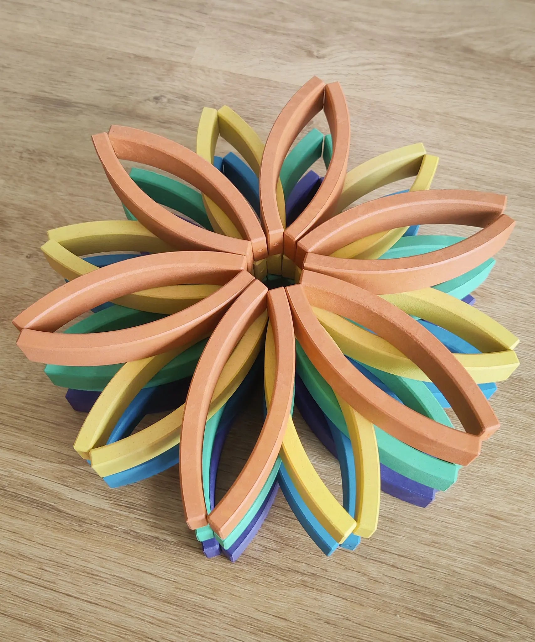 Abel blocks mini rewood Rainbow wooden stacking blocks stacked up in flower shapes in colour order.
