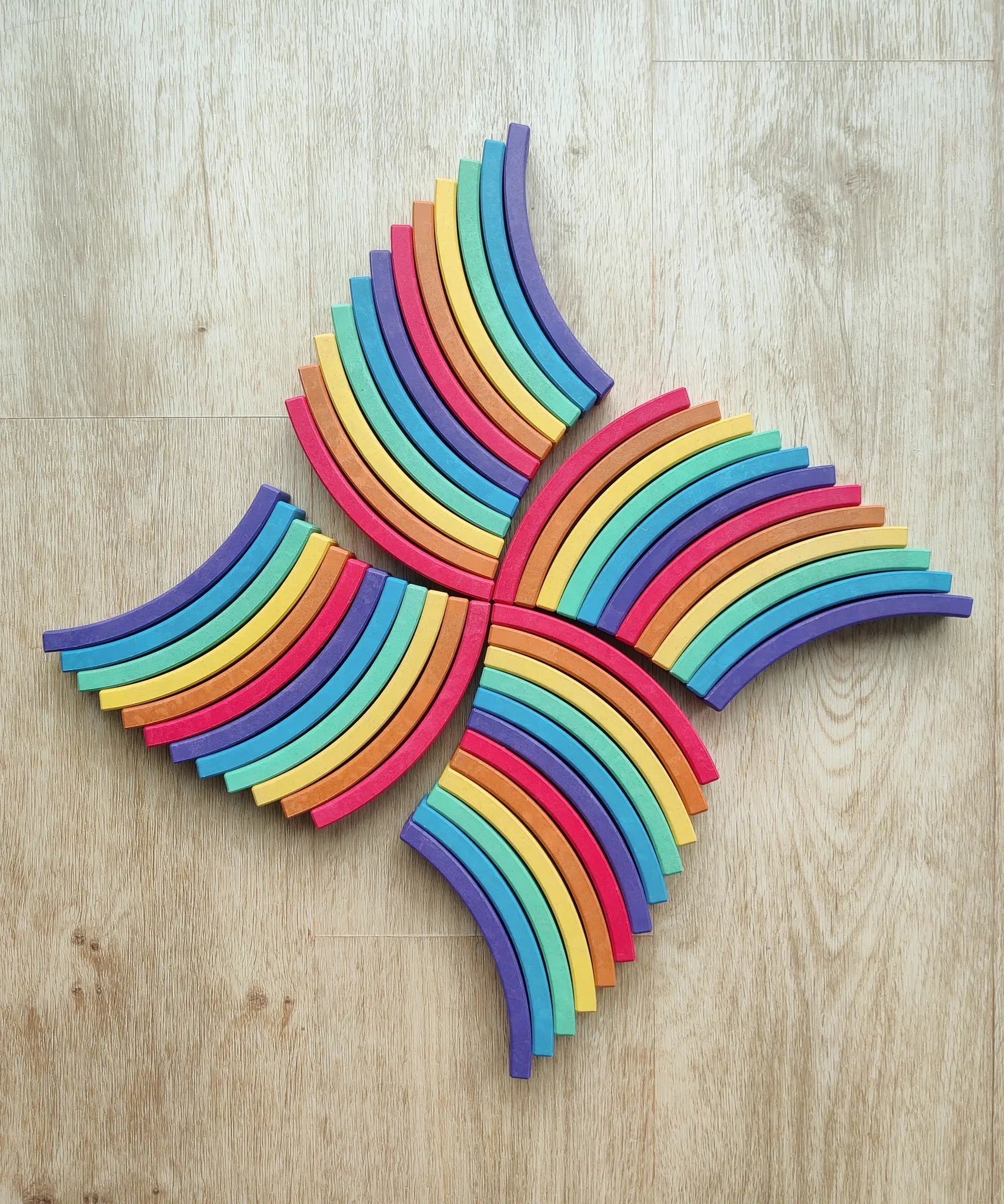 Abel blocks mini rewood Rainbow wooden stacking laid out on a wooden surface.